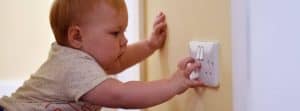 close up of baby playing with electric power point