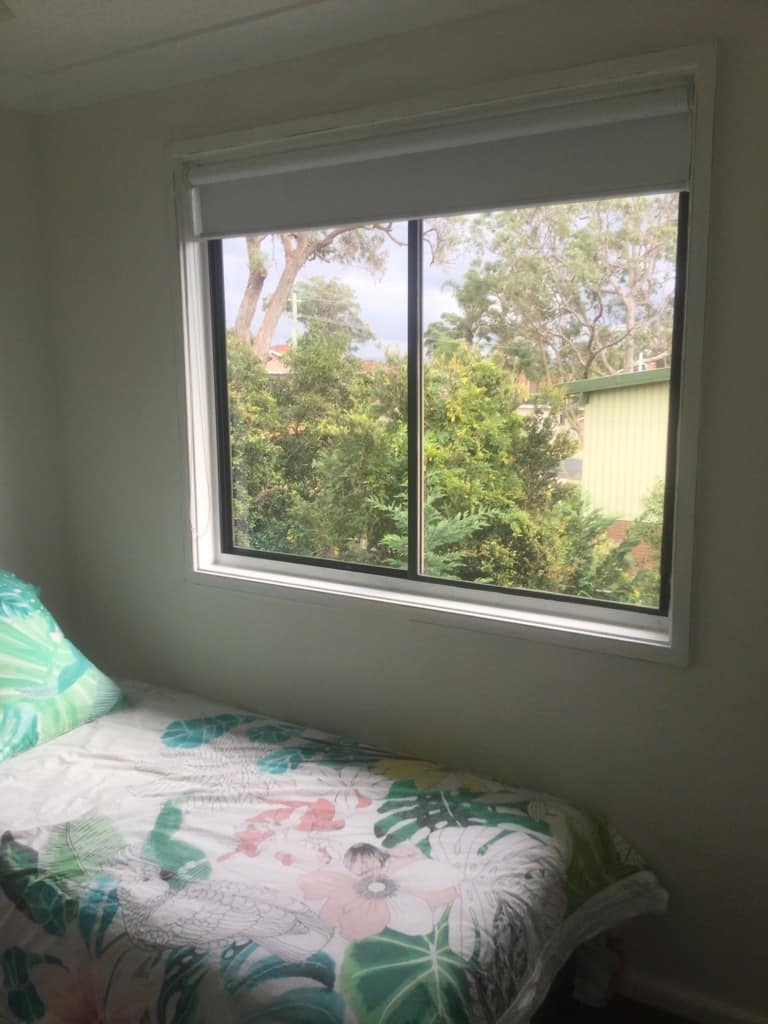 single bed next to bedroom window